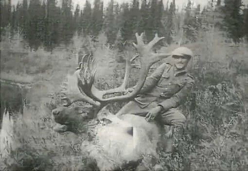Georges Rock pose près d’un caribou qu’il a chassé