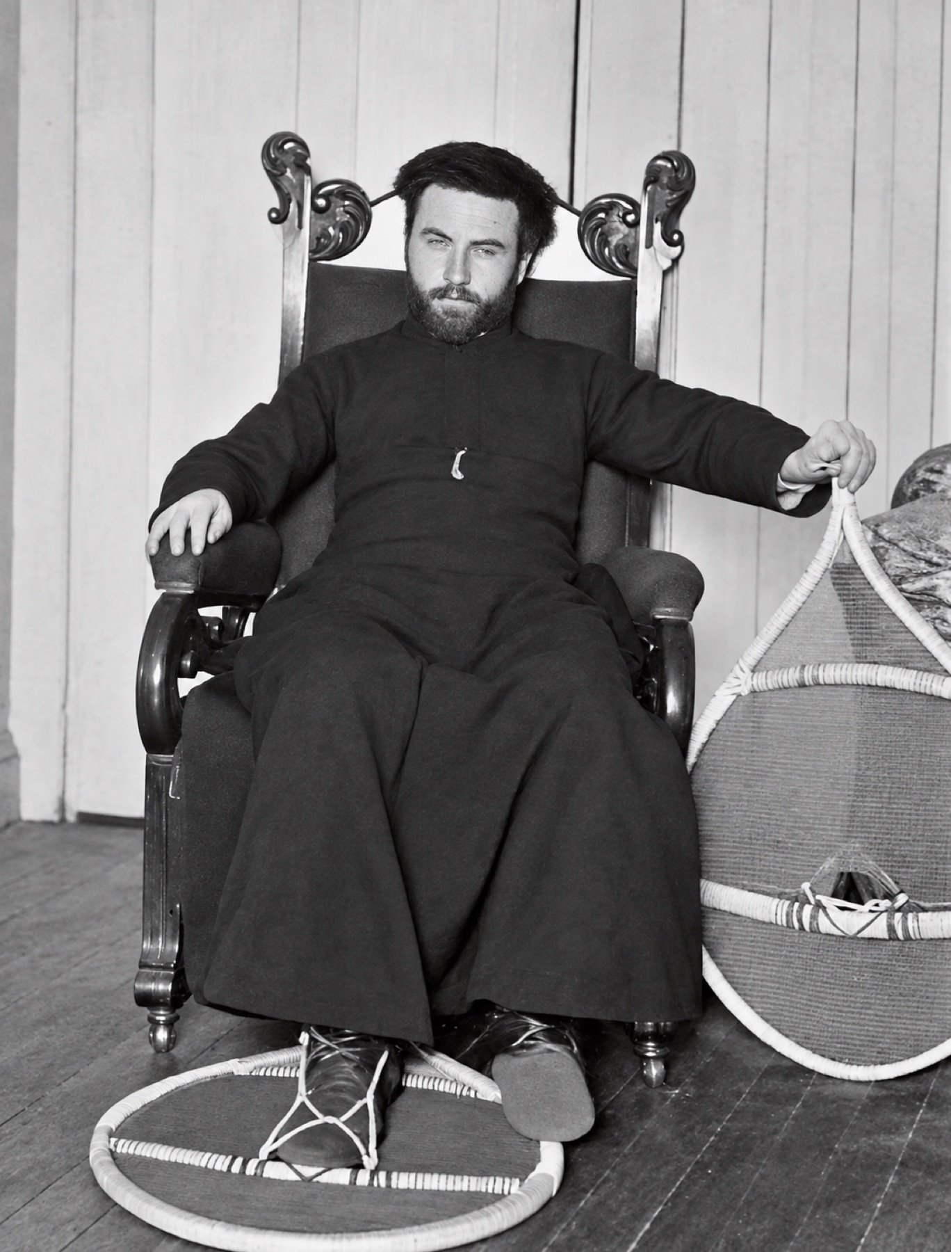 Le Père Le Jollec assis dans un fauteuil, avec ses raquettes