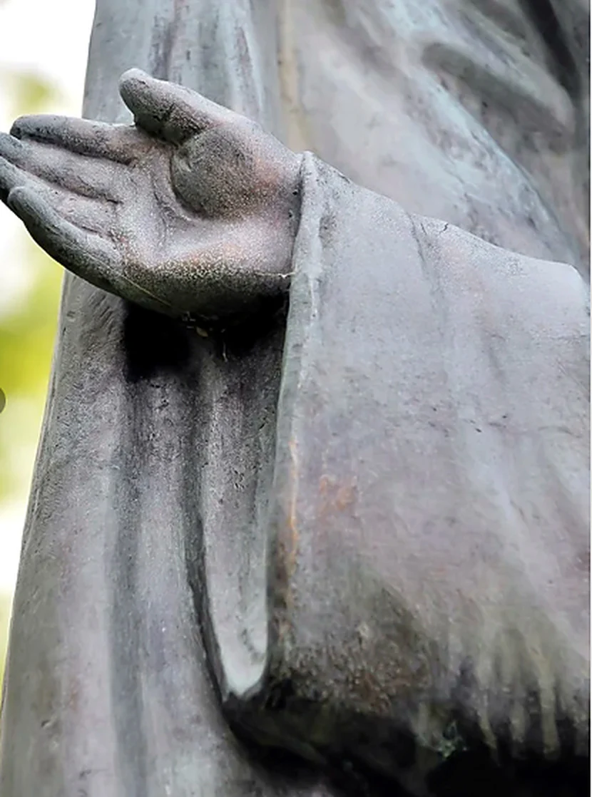 Mano aperta della statua, con il palmo rivolto verso l’alto